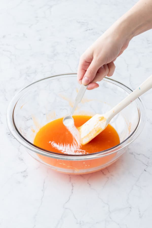 Adding baking soda to the persimmon puree.