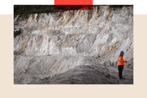 Getty Images An employee walking in the open-pit mine at a lithium plant