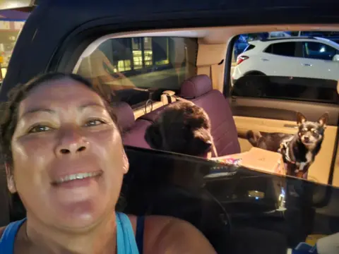 Felicia Johnson A selfie by Felicia Johnson shows the woman herself, plus her vehicle with two dogs inside