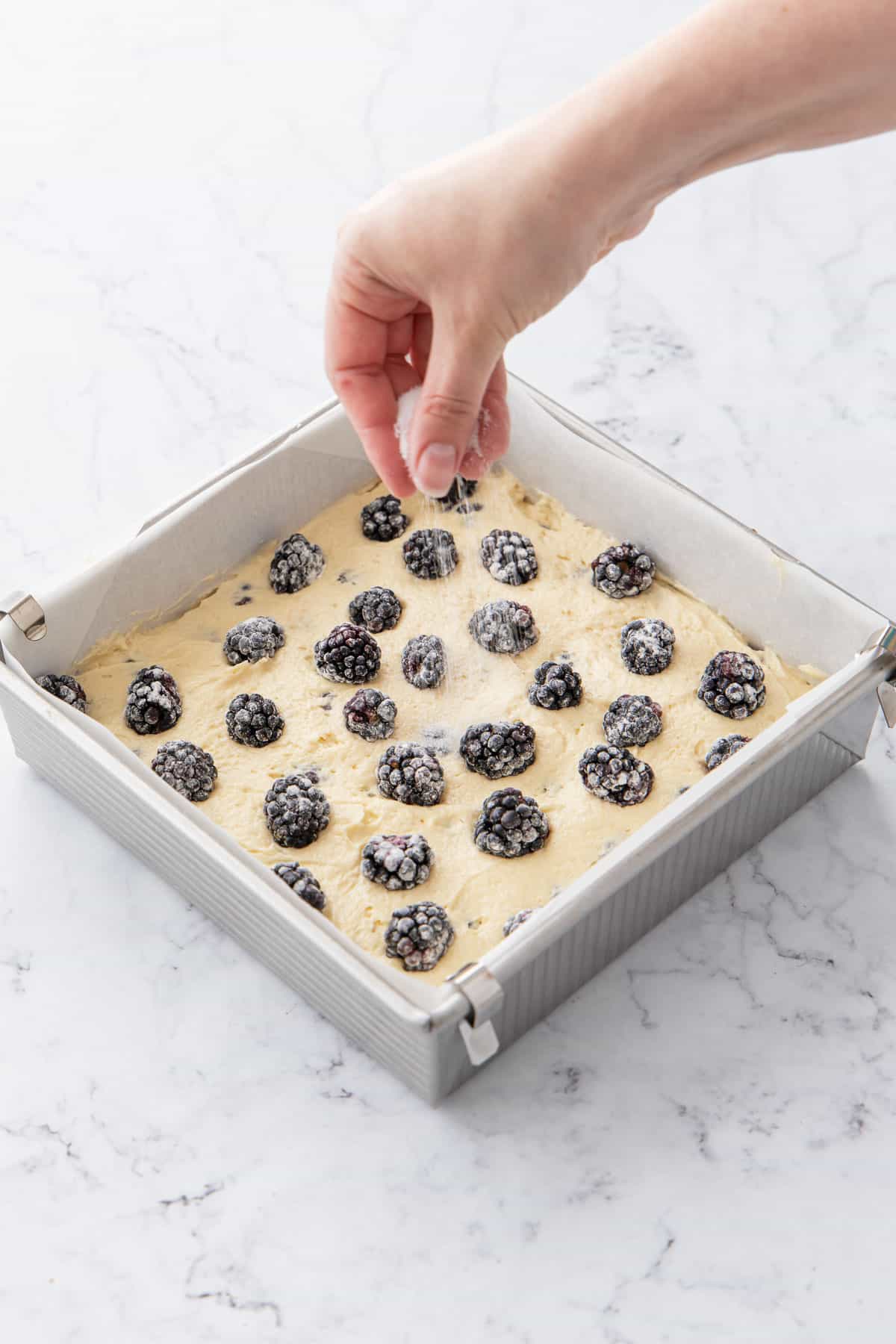 Sprinkling granulated sugar over top of cake before baking.