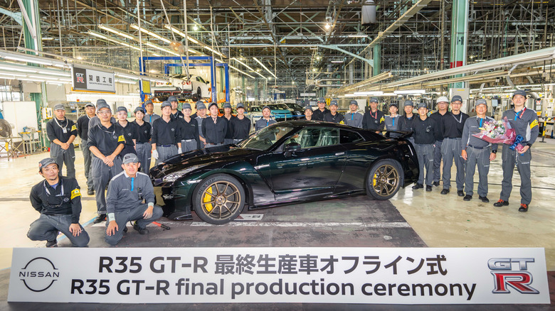 A Midnight Purple GT-R in the factory, surrounded by workers.