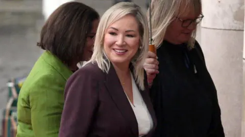 PACEMAKER Michelle O'Neill smiling. She is wearing a purple blazer with a white top. She has blonde hair.